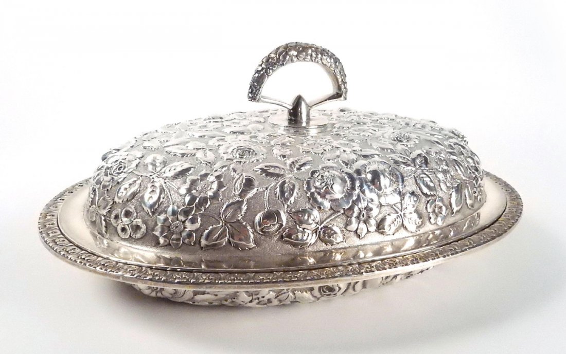 Sterling Repoussé Covered Casserole: Sterling silver robust masterful repoussé casserole with leafy floral decor featuring high relief cabbage elements. Lid bears detachable handle. Casserole interior bottom bears an engraved cipher. [1