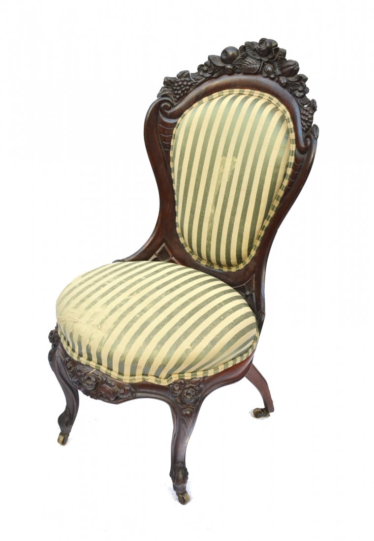 Victorian Rosewood Slipper Chair: In the manner of Belter. Carved floral and fruit crest and apron. [35" H x 18" W x 19" D]. Loss to back leg, general wear to surface and upholstery.