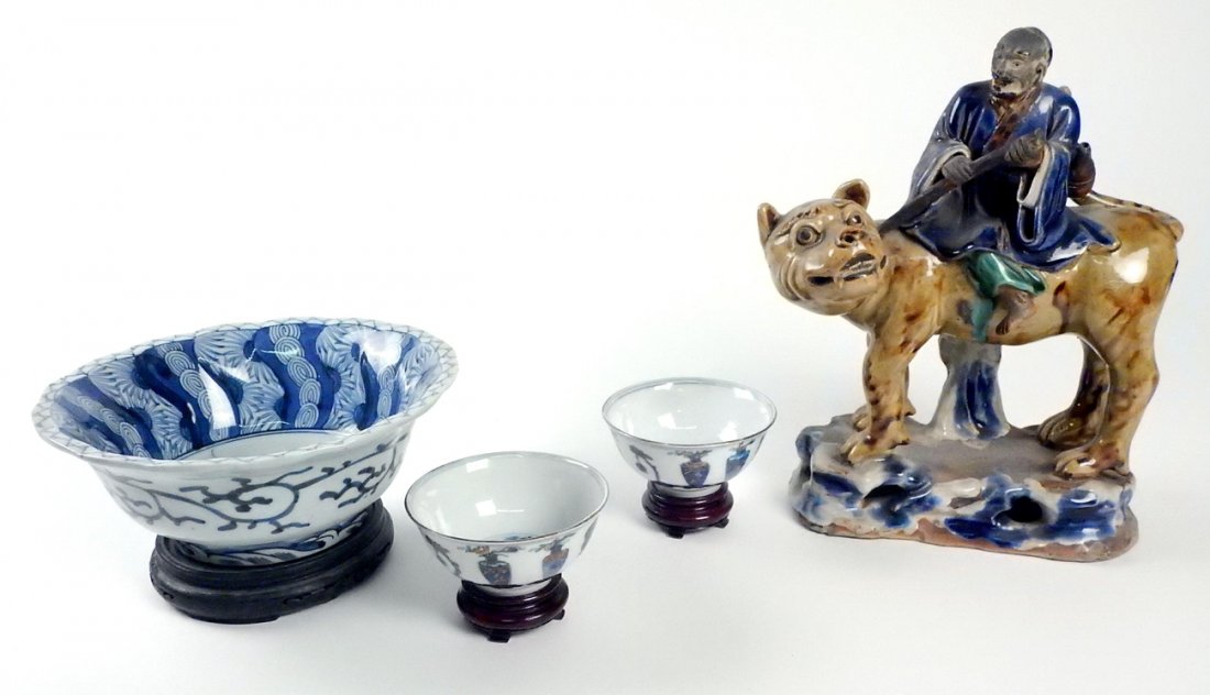Lot of 4 Asian Ceramic Articles: Comprises: 1.) Chinese glazed earthenware figure of a man on a mythical beast. [10 3/4" H x 9" W]. Head repaired. 2.) Porcelain blue and white bowl. [8 1/4" D x 3 1/4" H]. Chipped. 3 and 4.) Pair of s