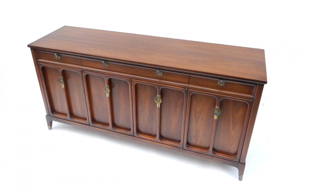 Danish Style Walnut Low Dresser: Comprised of pull out drawers behind doors bearing concave panel design with three shallow drawers at top. Brass feet and circular handles. [67" W x 99" D x 33 1/2" H]. Nicks, scratches.