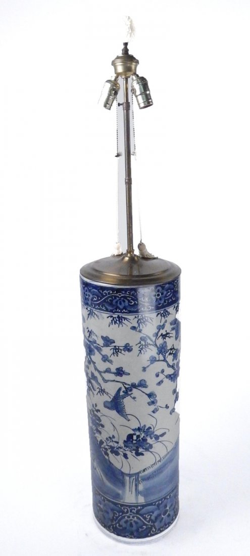 Asian Porcelain Lamp: Asian blue and white ceramic umbrella stand mounted as lamp. [8" Dia x 24" H (45" H to finial)]. Spider crack on bottom.