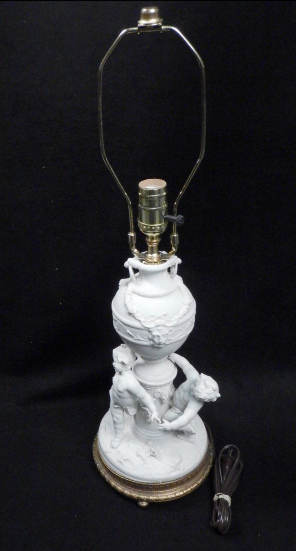 Bisque "Ring Around the Rosie" Lamp: White glazed lamp with three frolicking cherubs in the Sevres manner. [18" H to socket]. Minor losses, otherwise in overall good condition.