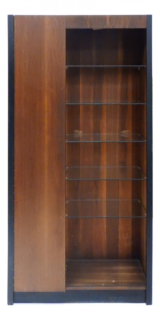 Milo Baughman, Bookcase Cabinet: Walnut cabinet with open bookcase at right side bearing five glass shelves and tall narrow door at left concealing three shelves. Bears ebonized trim at sides and base. [38" W x 14" D x 76" H]. Minor 