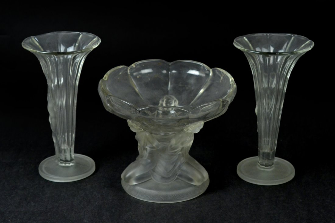 Three-Piece Lalique-Style Garniture: A pair of raised figural vases, together with a raised figural centerpiece. [9" Dia x 9 3/4" H (largest)]. Good condition.