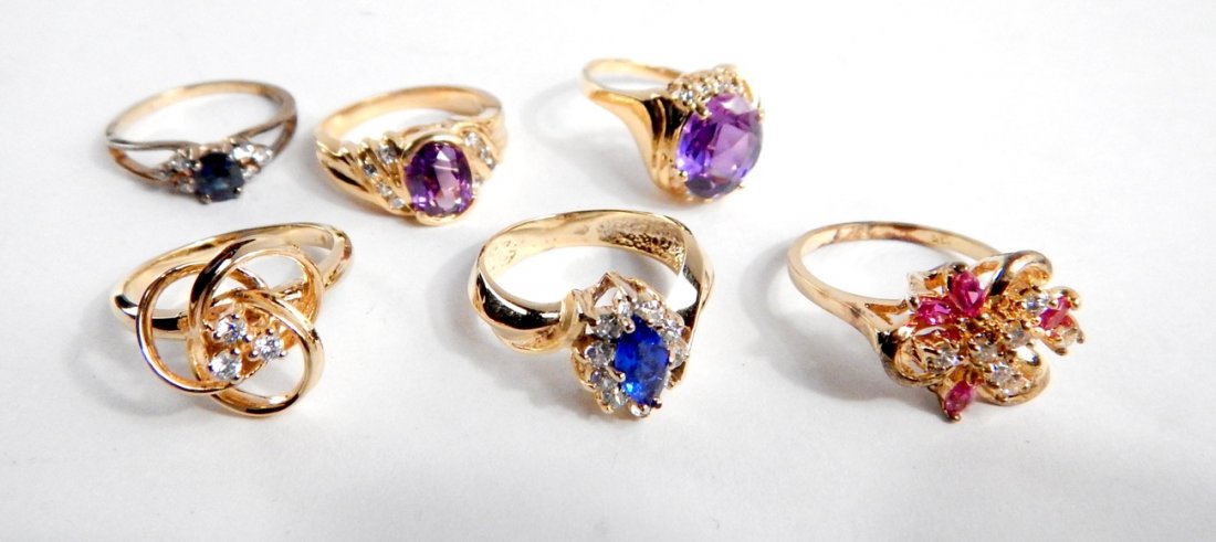 Six Costume Rings: 6 gold-tone rings with fancy settings bearing various color paste stones.