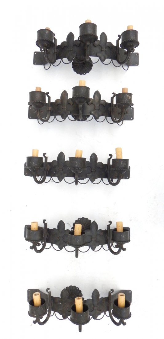 Set of 5 Renaissance Revival Sconces: Set of 5 Renaissance Revival-style 3-arm blackened steel bowed sconces bearing Edison-base sockets and fleur-de-lis accents. [24" W x 10 3/4" D x 7" H to sockets]. Light oxidation, scuffs and scratche