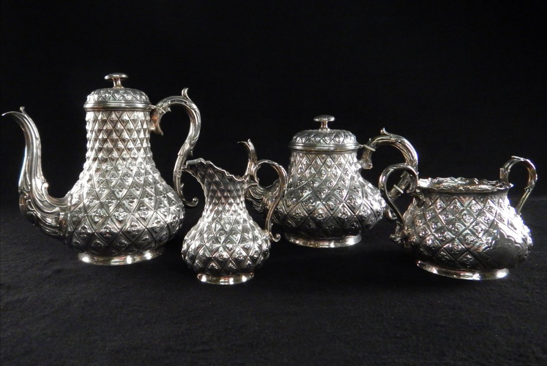 Four-Piece Sterling Silver Tea Set: Four-piece sterling silver tea set comprising teapot, coffee pot, sugar bowl and creamer in diamond quilt pattern. Marked "F. BRs". [Teapot: 7 1/4" H x 10 1/4" W]. 24.465 ozt. [Coffee pot: 9 1/2" H x 