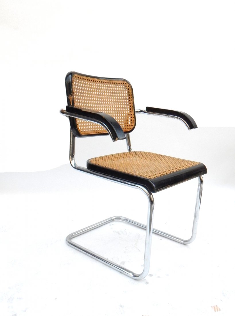 Mid-Century Marcel Breuer Armchair: Features caned back and seat with black lacquer and steel frame. [24 1/2" W x 21 1/2" D x 32 1/2" H]. Chips and losses to lacquer.