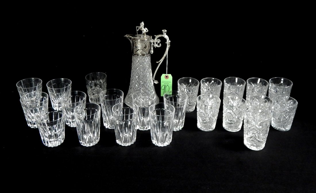22 Crystal Tumblers and Ewer: 22 crystal tumblers in mulitple patterns. Includes 5 "Stuart" whiskey glasses. Accompanied by a ewer. [Sizes from: 3 1/2" H to 4" H; Ewer: 5 1/2" Dia x 11" H]. Small chips.