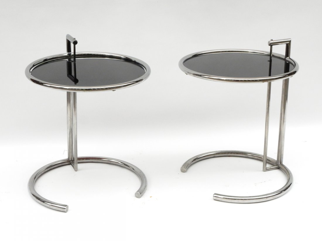 Pair of Eileen Gray Tables: Two chrome silver-finish round tables with smoked glass tops. [20 1/2" Dia x 24 1/2" H]. In good condition.