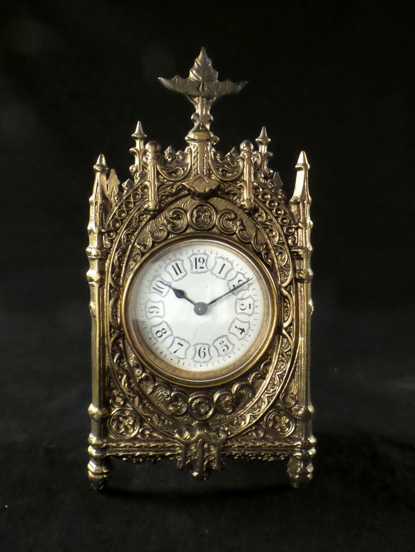 Gothic Brass Clock: Early 20th century clock with a removable back, includes the key. [3 3/4" x 2" x 8" H]. In good condition.
