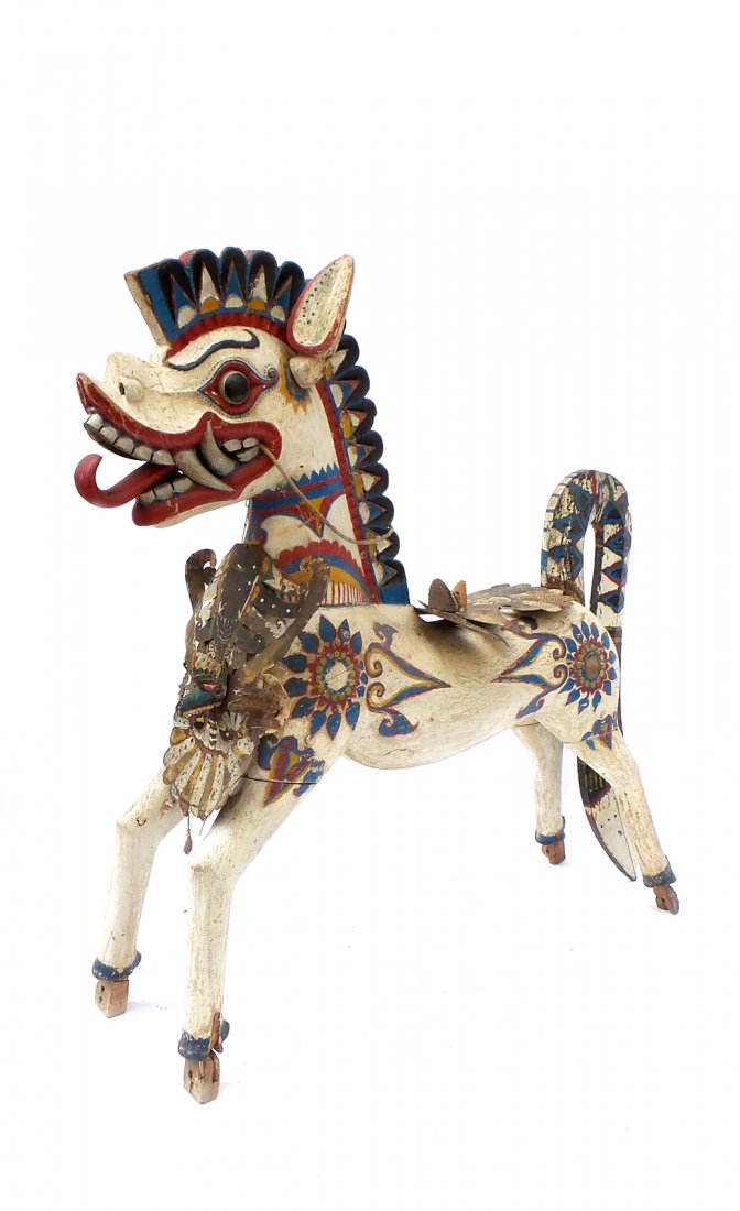 Balinese Carved Wood & Painted Horse: Balinese painted carved wood sculpture of a horse, with removable tail, and decorated with pierced metal garuda. [58" W x 12" D x 51" H]. In overall good condition commensurate with age.