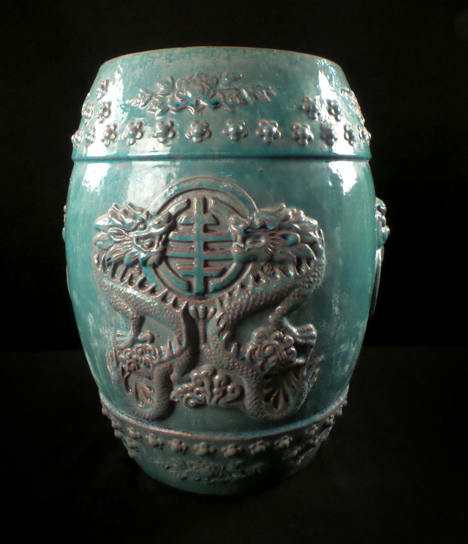 Chinese Porcelain Green Glazed Stool: Chinese porcelain teal green glazed stool with bas-relief dragon and foo lion motif. [15" Dia x 18" H]. Good condition.