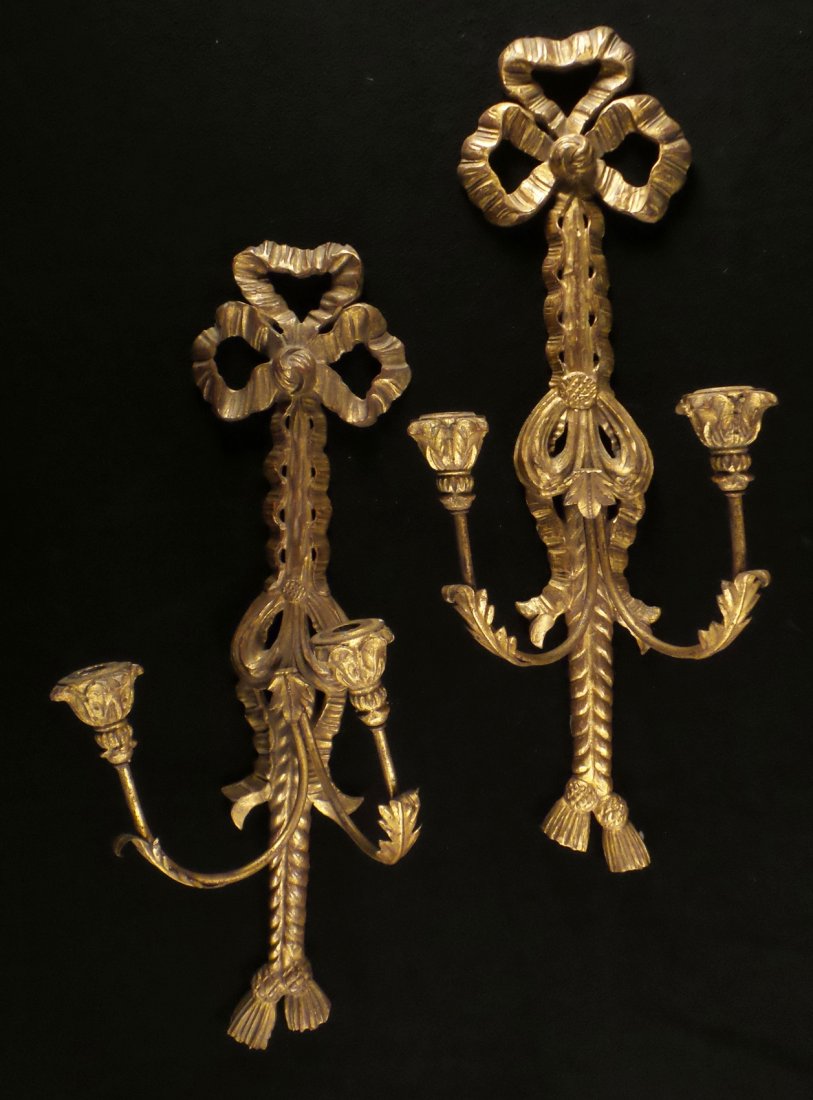Pair of Gilt Wood Carved Sconces: Pair of carved wood gilt two-armed sconces with bow and tassel motif. [27" L x 9" W]. In good condition.