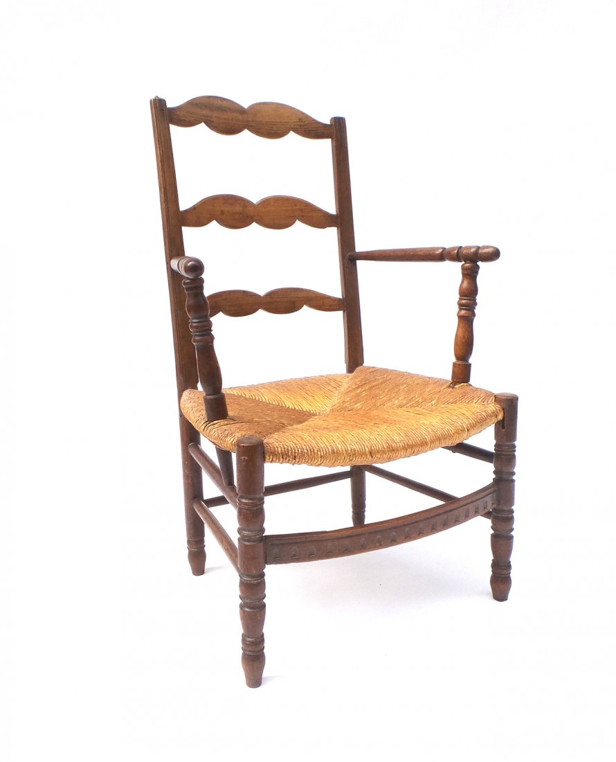 Antique American Oak Armchair: Turned oak open armchair with rushed seat and jigsaw ladder back. [20 1/2" W x 19 1/2" D x 35" H; 13 1/2" H to seat]. Joints loose.