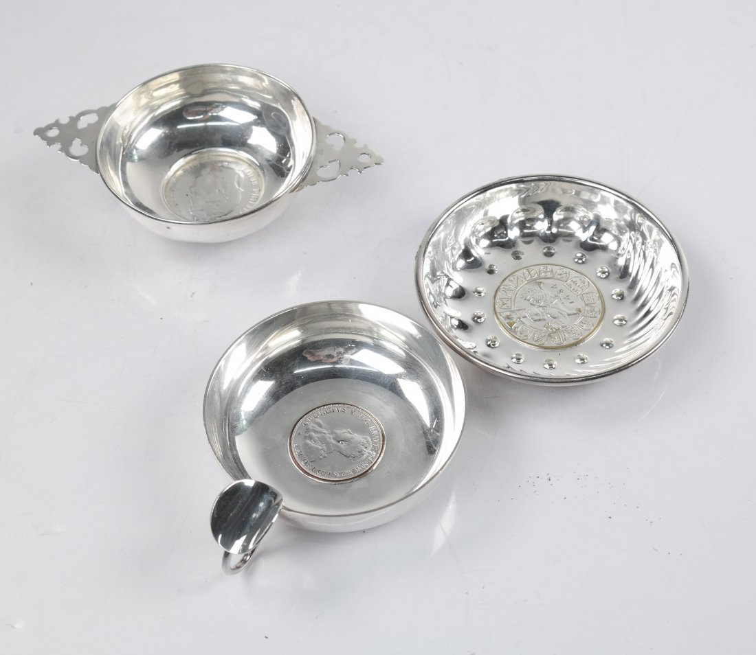 Three Wine Tasters, Sterling and Plate: Group of three wine tasters comprising: 1.) A sterling silver taster marked "1845, 5 Frmes". [3" x 5" x 1/4" H]. 2.19 ozt. 2.) Two silver plate wine tasters. [3 1/2" Dia and 4" with thumb rest]. In go