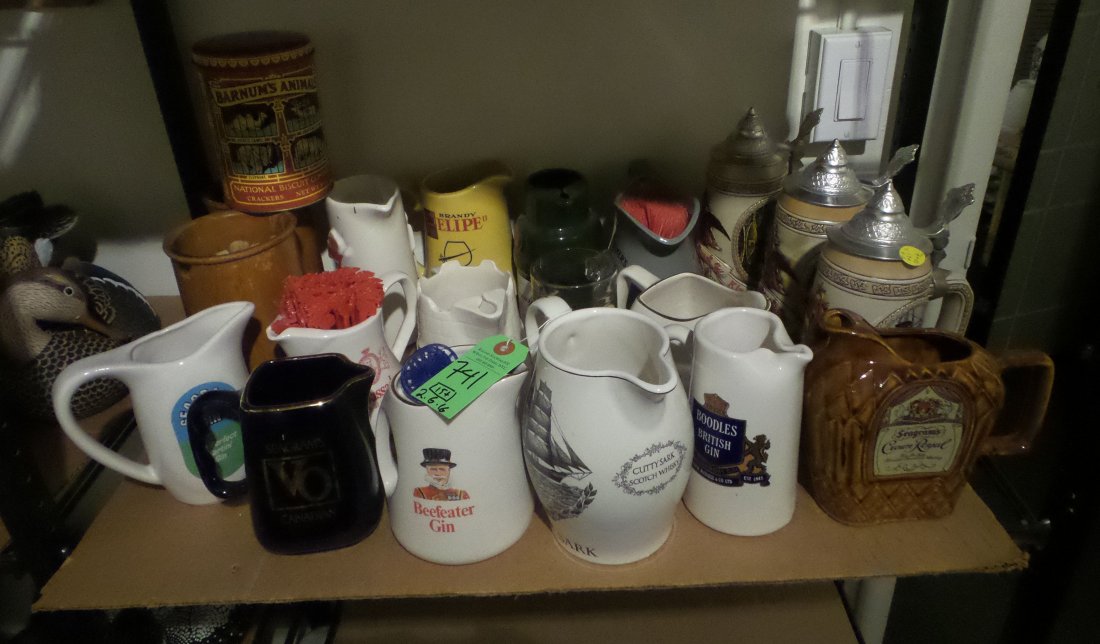 Group of Advertising Pitchers, Steins: Group of 15 plus advertising pitchers and steins including: Beefeater Gin, Seagram's Crown Royal, Ambassador Felipe Brandy, Anheuser Busch, and others. [5 1/2" H to 9 1/2" H]. In good condition.