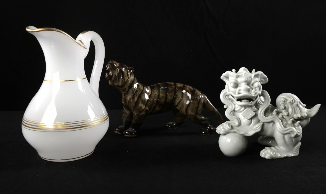 Three Decorative Items: Comprising: 1.) Blanc de chine foo dog. [8" x 5" x 6 1/2" H]. In good condition. 2.) Glazed ceramic tiger. [10" x 3" x 7" H]. Two teeth broken. 3.) White opaline pitcher with gilt bands.