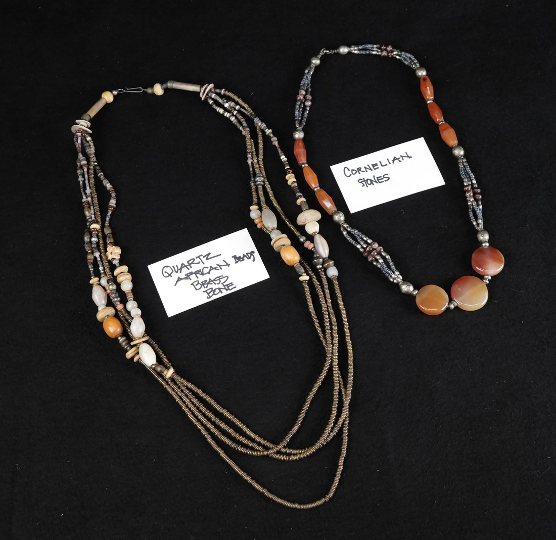 Two Necklaces: One strand having carnelian stones and the other made of quartz, African beads, brass bone [12"; 32" L].
