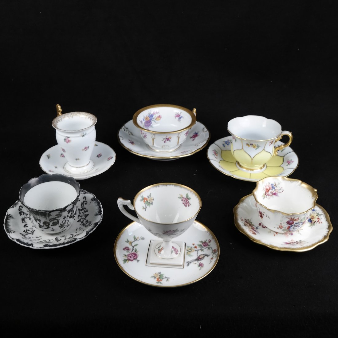 Group of Vintage Tea Cups and Saucers: 6 tea cups and saucers. 1) Charcoal and white marked KPM [2 1/2" H; Saucer 5 3/4" Dia]. 2) Gold handled and rosebuds marked limoges, A Lantermier [4" H; Saucer 5 1/2" Dia]. Paint has worn off from usa