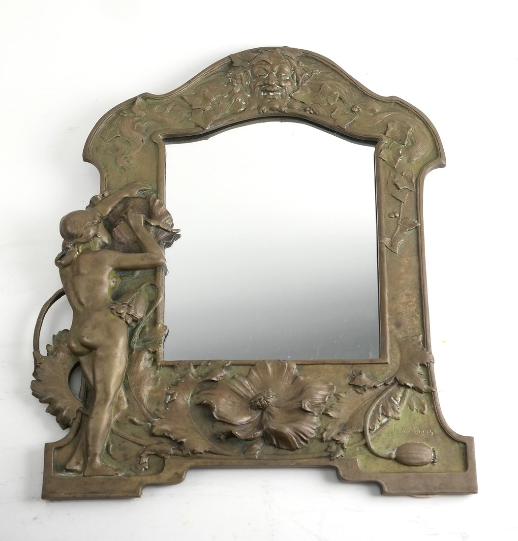 Art Nouveau Patinated Bronze Mirror: Bronze mirror inscribed "HC Luers" in the lower right, the shaped frame cast with a nude, an allegorical mask, ivy and poppies. [17 3/4" H x 12 3/4" W]. Some minor surface wear with a replaced mirror 