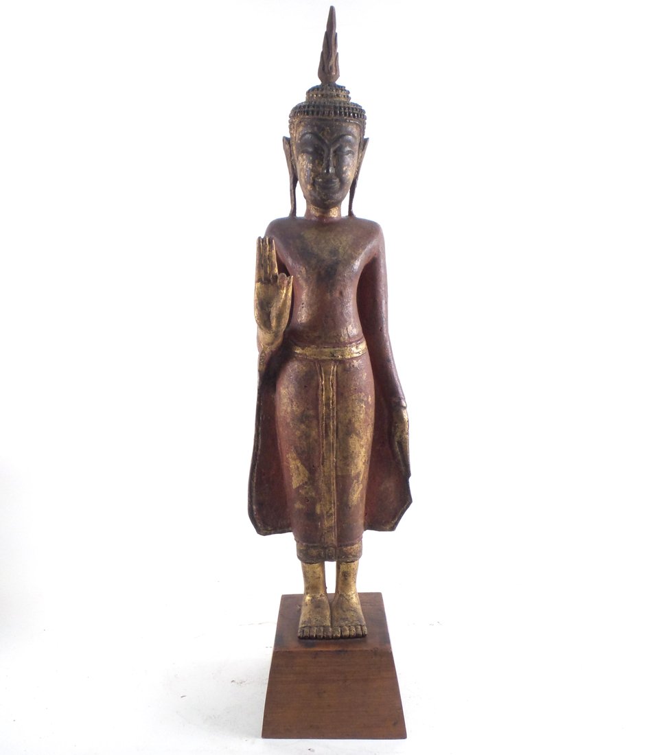 Southeast Asian Standing Diety: Southeast Asian painted and gilt wood deity. [7 1/2" x 5" x 27 1/2" H]. Loss to finger of raised hand.