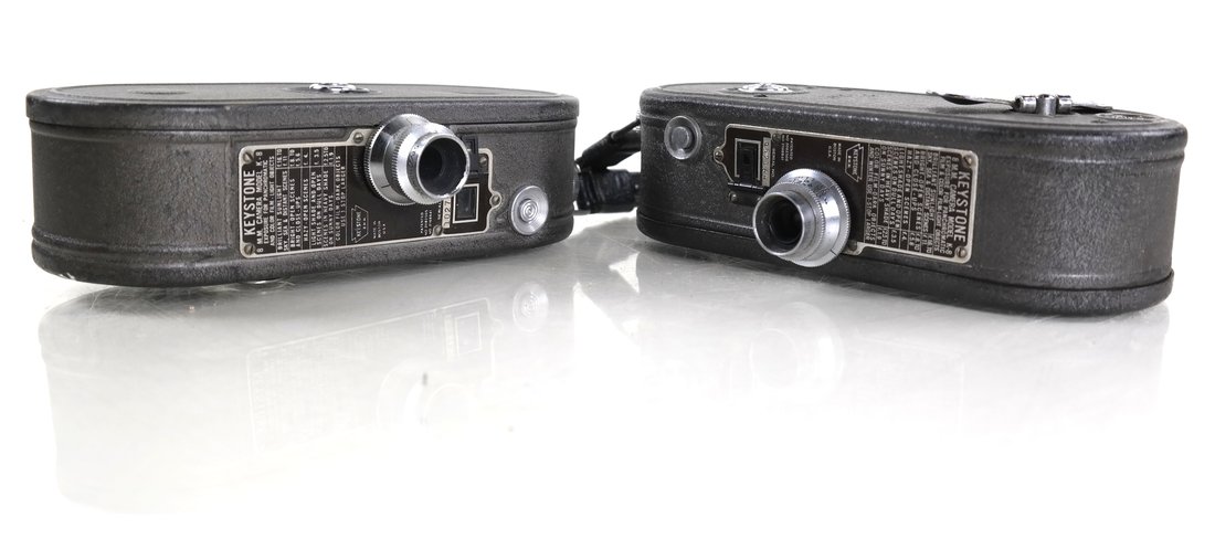 Pair of Keystone Cameras: Two 8 mm cameras in brown satin housing. Dimensions: 1.75 " W x 3.75 " H x 6.50 "D each ; 