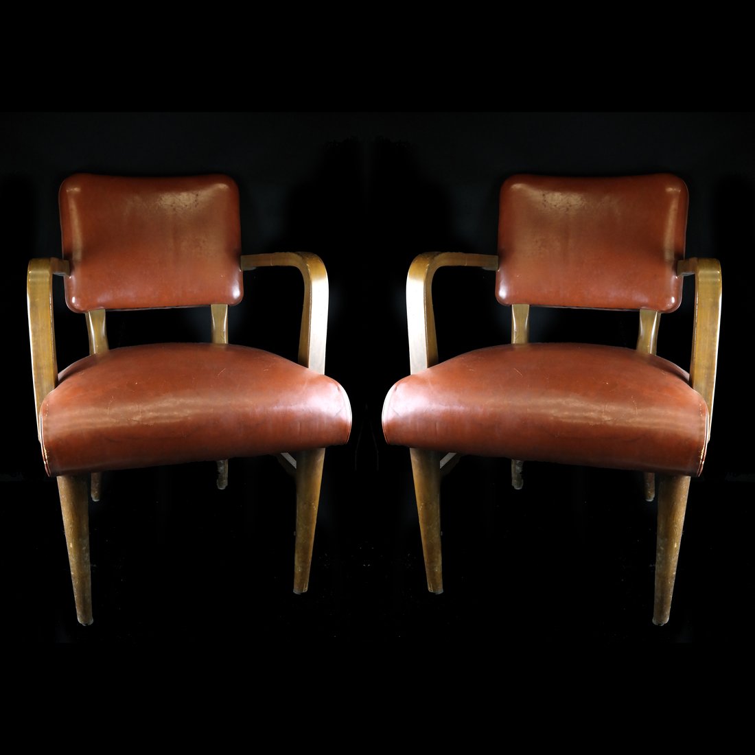 Pair of Leather Armchairs: Pair of brown upholstered open leather armchairs with oak frames. [33 1/2" H x 21 1/2" L x 23" D; 17 1/2" H to seat]. Worn.