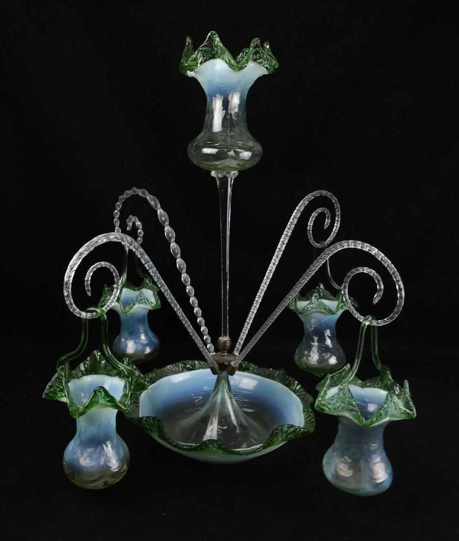Victorian Glass Epergne: Victorian glass epergne with a gradient of opaline to green glass. Bears four twisted flutes and four hanging baskets. [22 1/2" H x 21" D]. Has some chips, one flute is replaced. One metal holder "as