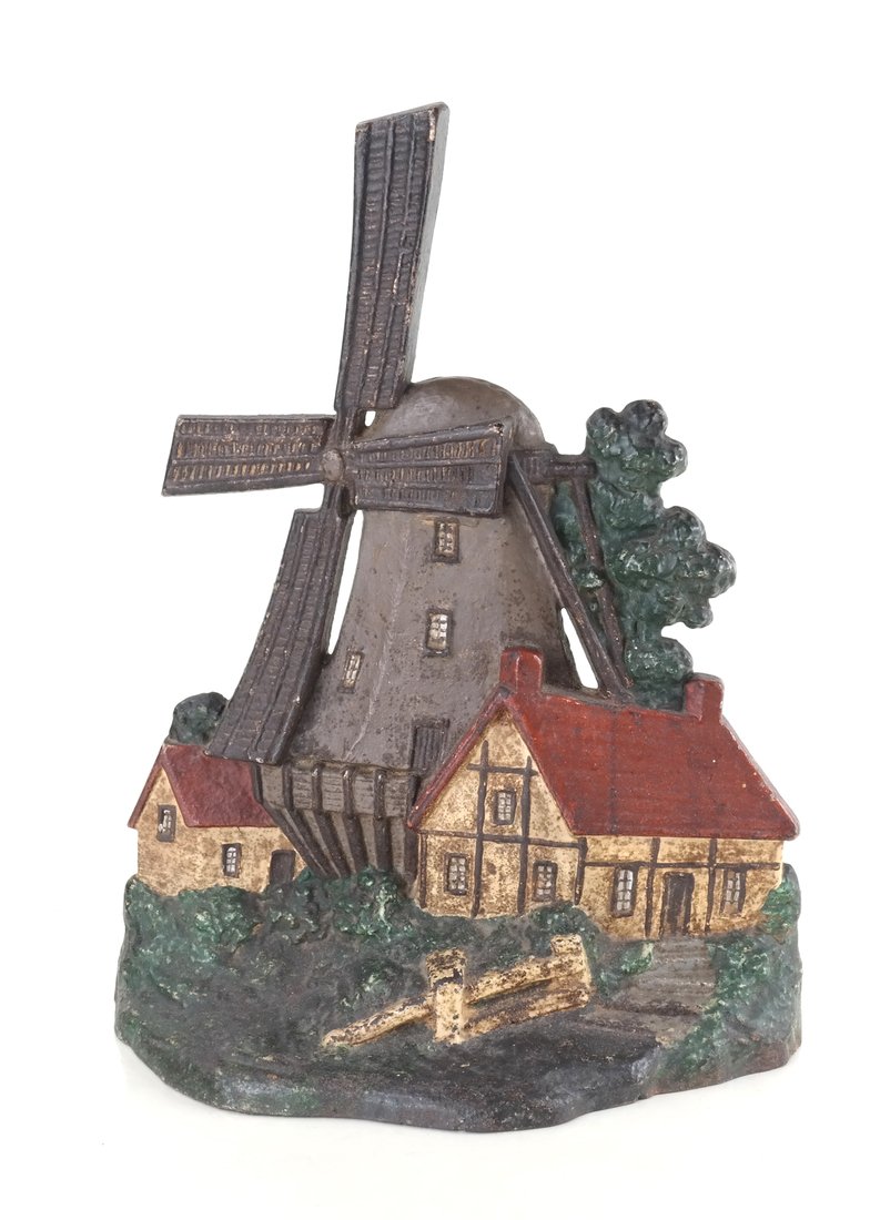 Painted Cast-Iron Windmill Doorstop: Modeled and painted as a large windmill centered by two red-roofed cottages. [11 1/2" H x 9" W].