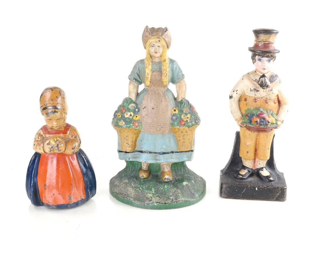 Three Painted Cast Iron Figural Doorstops: Each hollow-cast relief figures comprising: Dutch Girl by Hubley Mfg. Co., a younger version of Dutch Girl, and Boy with Fruit Basket. [Height: 9 1/2" to 6 1/4; Width: 3 3/4" to 5 3/4"].