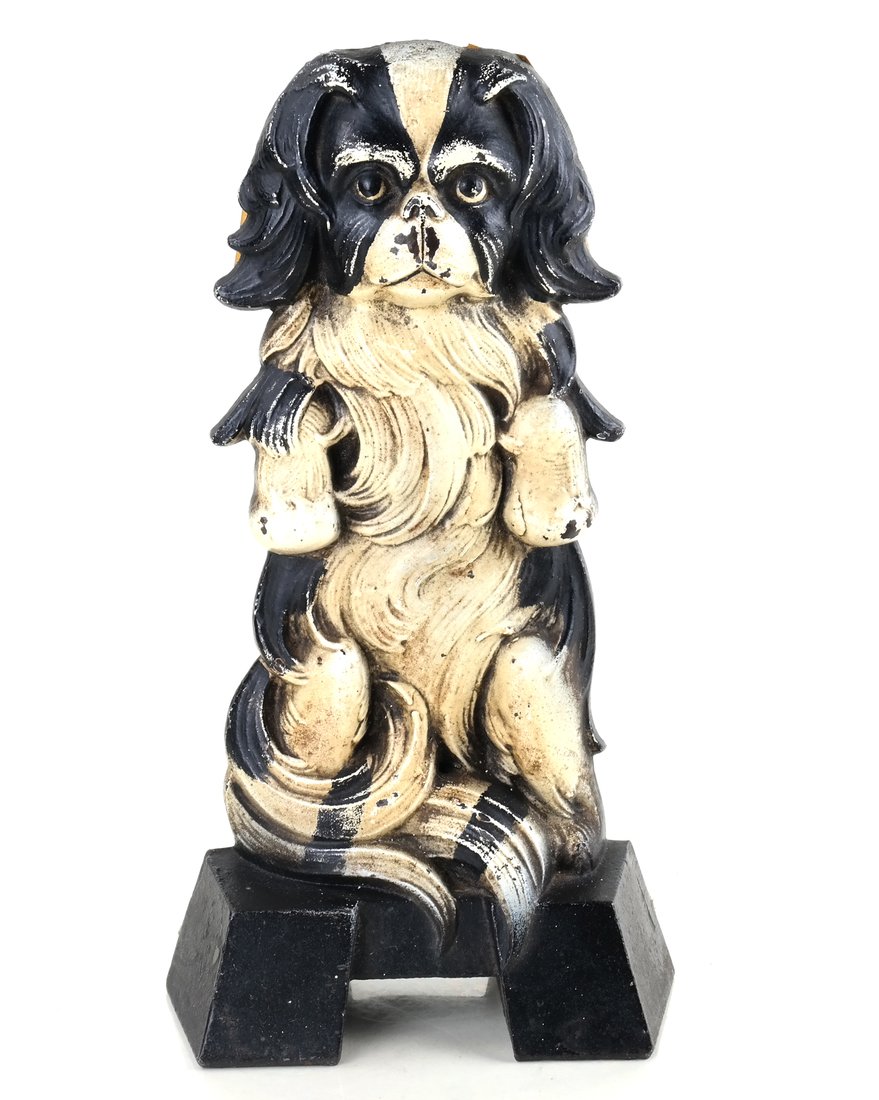 Painted Cast Iron Spaniel Doorstop: Named "Japanese Spaniel, (1267)", the reverse impressed "1267" within a rectangular cartouche; modeled as seated on his hind haunches, painted black and white. [9" H x 4 1/2" W].