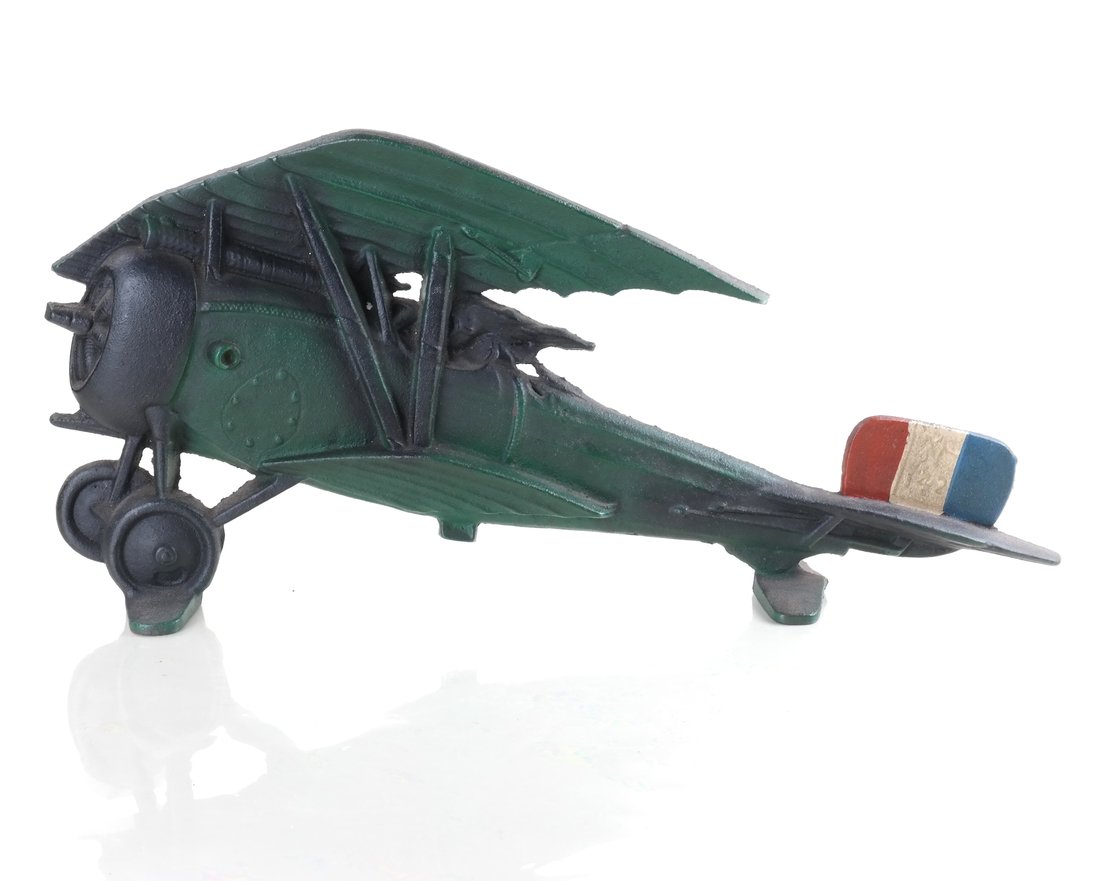 Cast Iron WWI Plane Doorstop: Modeled and painted as a French WWI fighter plane, the red, white and blue tail impressed "142". [ 8 3/4" H x 19" W]..