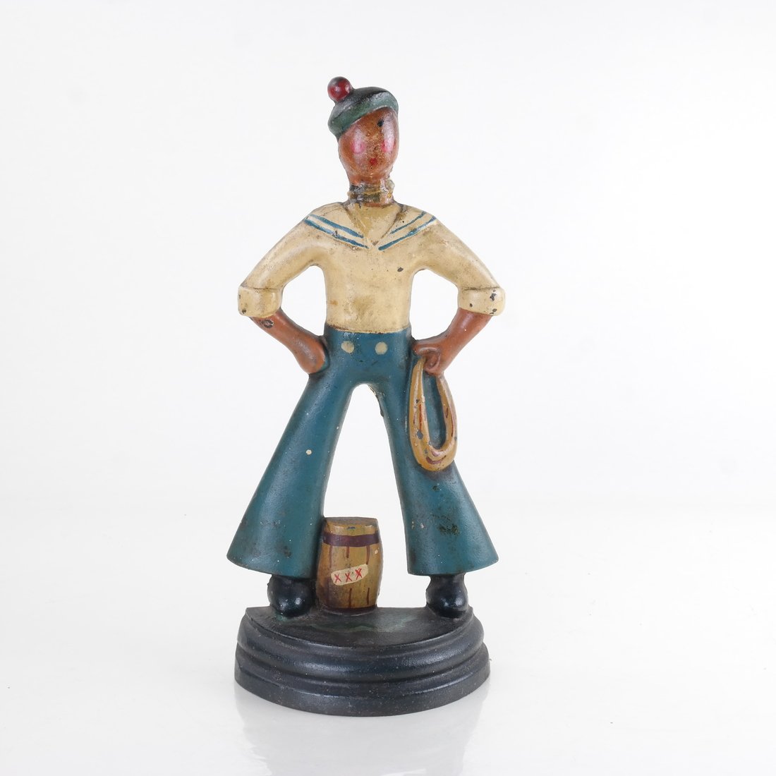 Painted Cast Iron Sailor Doorstop: Modeled as standing with a barrel between his feet, and a gathered line in his left hand. [11 3/8" H x 5" W].