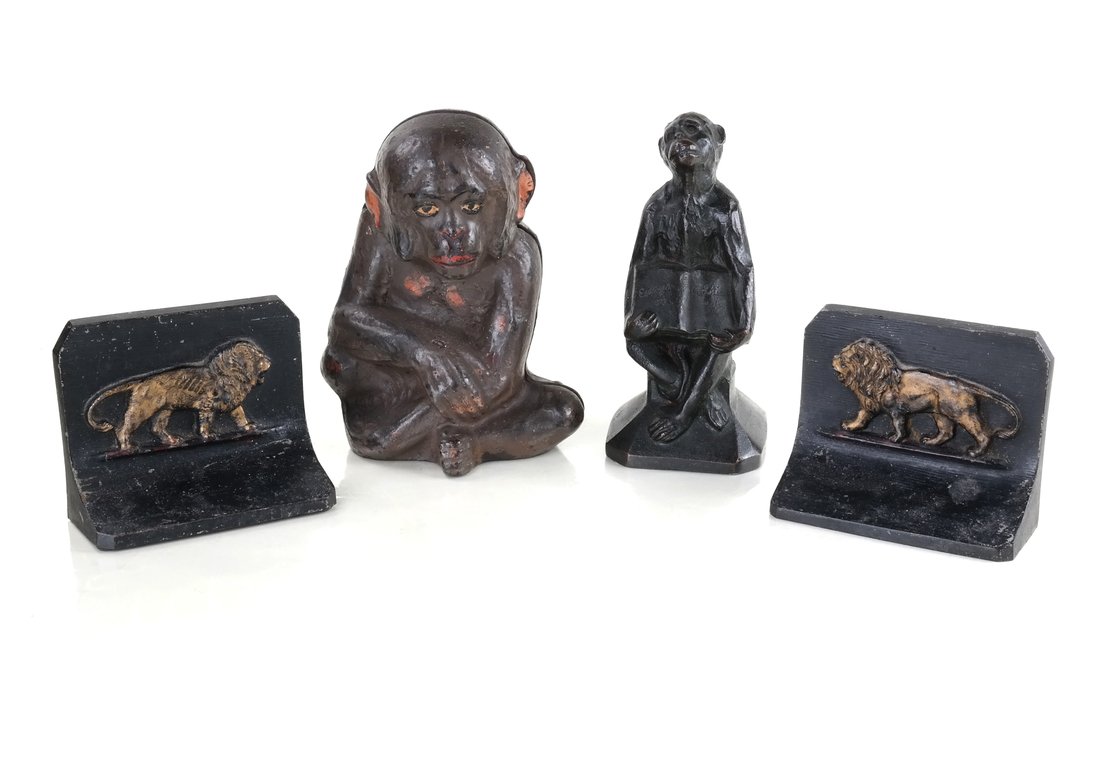 Four Cast Iron Exotic Animal Bookends: Comprises: 1.) Two parcel gilt, relief-molded, lion-form bookends by Bradly and Hubbard.Reverse of each impressed "B&H." 2.) Hollow-cast, full-bodied, figure of a seated monkey reading a book on evolu