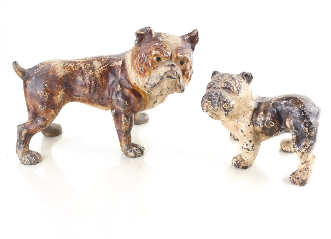Two Cast Iron Bull Dogs: By Hubley Mfg. Co., each doorstop modeled and painted as a hollow-cast, full-bodied standing dog, [Sizes from 4 3/4" to 6 1/4" H and 6" to 9" W].