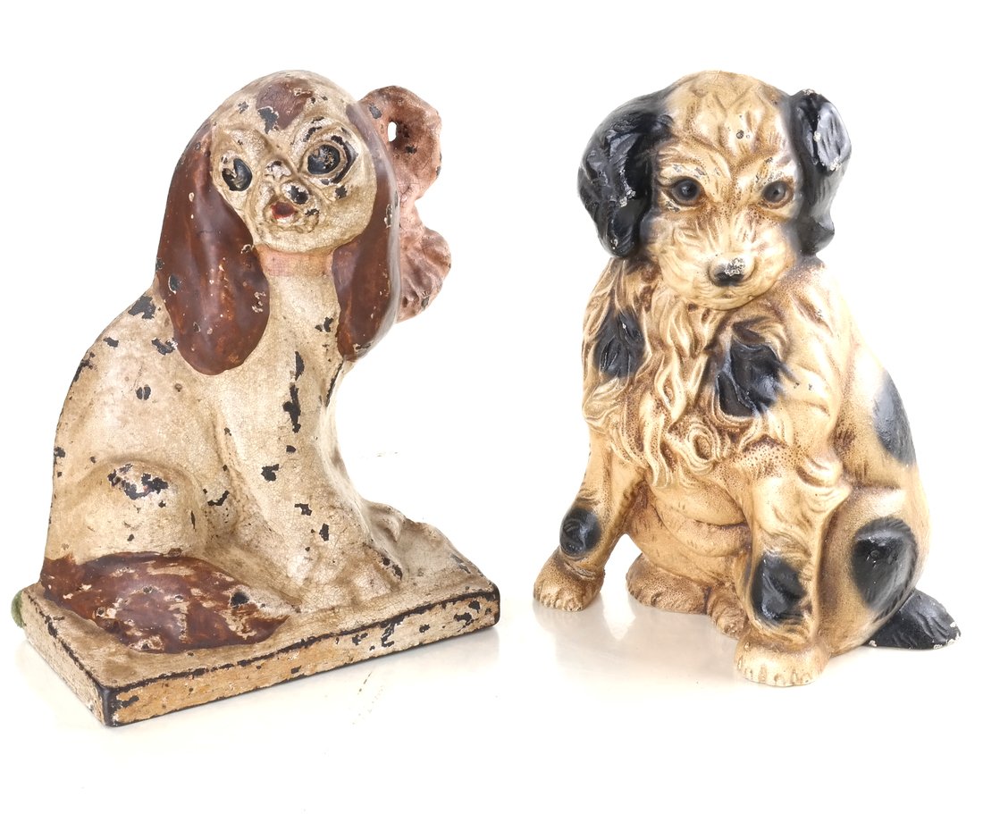 Two Cast Iron Seated Dogs: Comprising: a painted, relief-molded doorstop modeled as a spaniel pup, and a painted, relief-molded doorstop modeled as a King Charles Spaniel with a pink bow tied at her neck, [Sizes from 8 1/2" to 