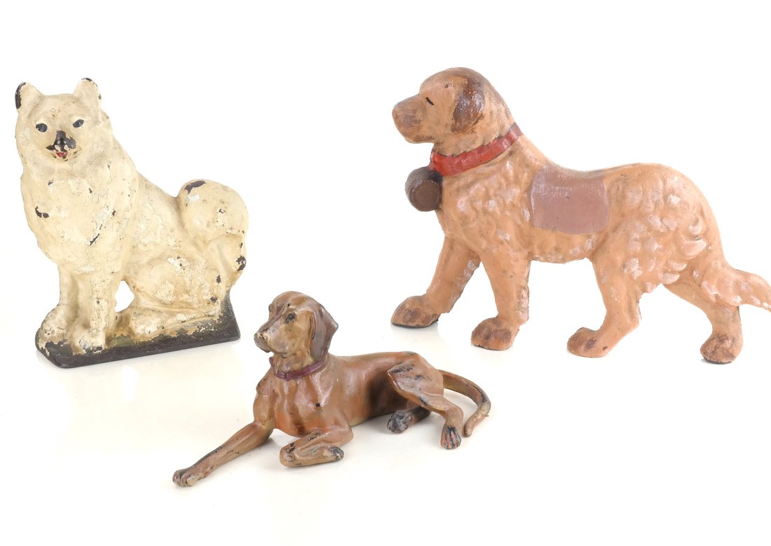 Three Painted Cast Iron Dogs: Comprising: a relief-molded and painted doorstop modeled as a seated Malamute probably by Creations Co., apparently unmarked, a relief-molded and painted doorstop modeled as a walking St. Bernard, and