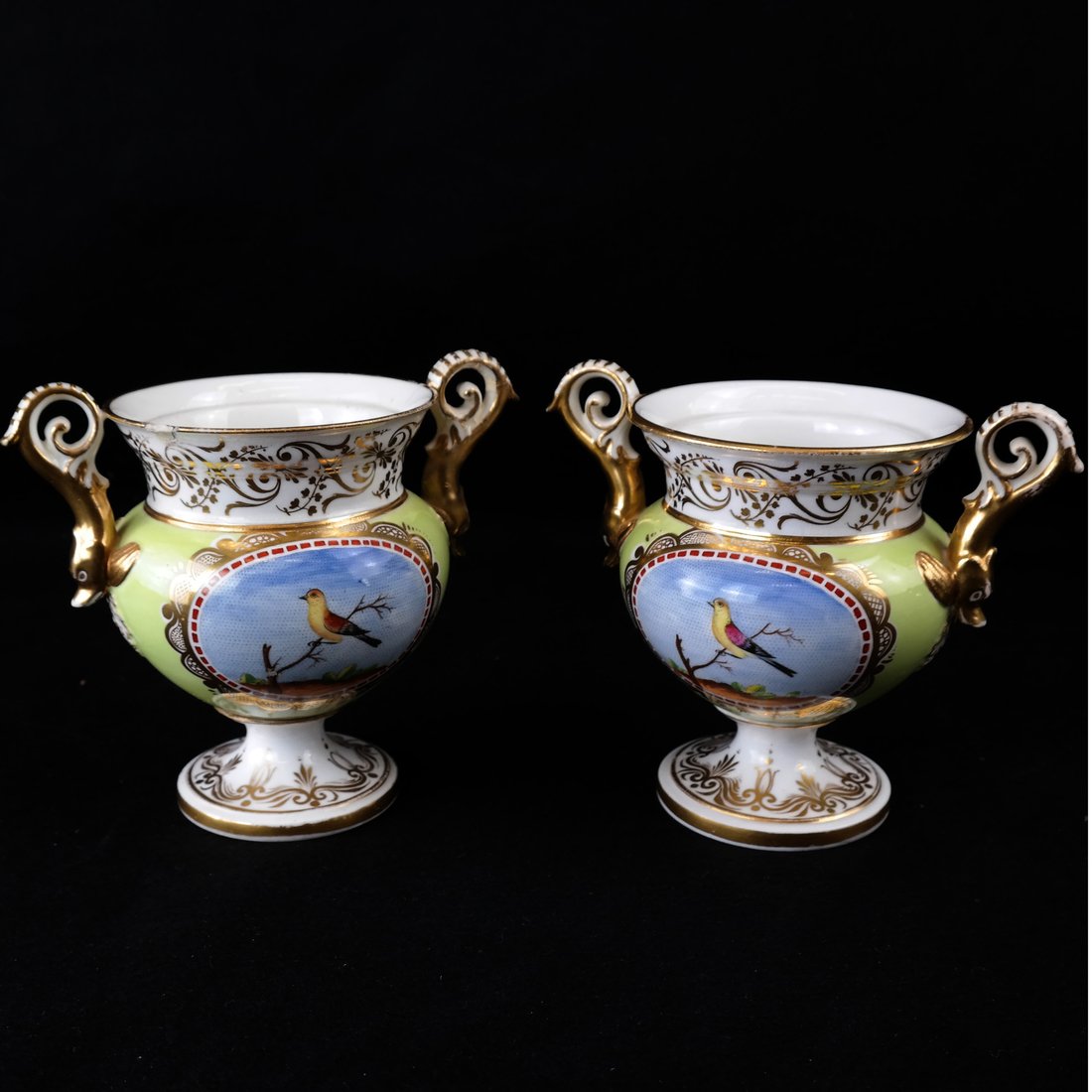 Pair Paris Porcelain Two-Handled Vases: 19th century, each painted with an ornithological reserve on a chartreuse ground, with gilt highlights, [H 4 1/2" x L over handles 6"], lacking covers, handles and few chips restored, some light wear 