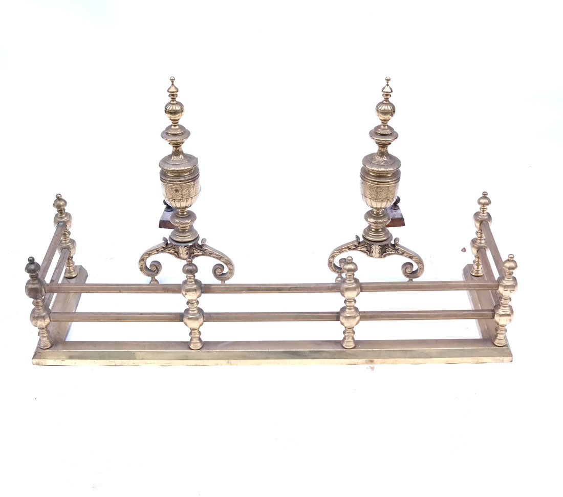 Three-Piece Fireplace Ensemble: Comprises a gilt metal hearth fender [11" H x 41" W x 14"D] together with 2 gilt metal andirons [22" H x 10" W x 22"D]. Scratches and scuffs from use.
