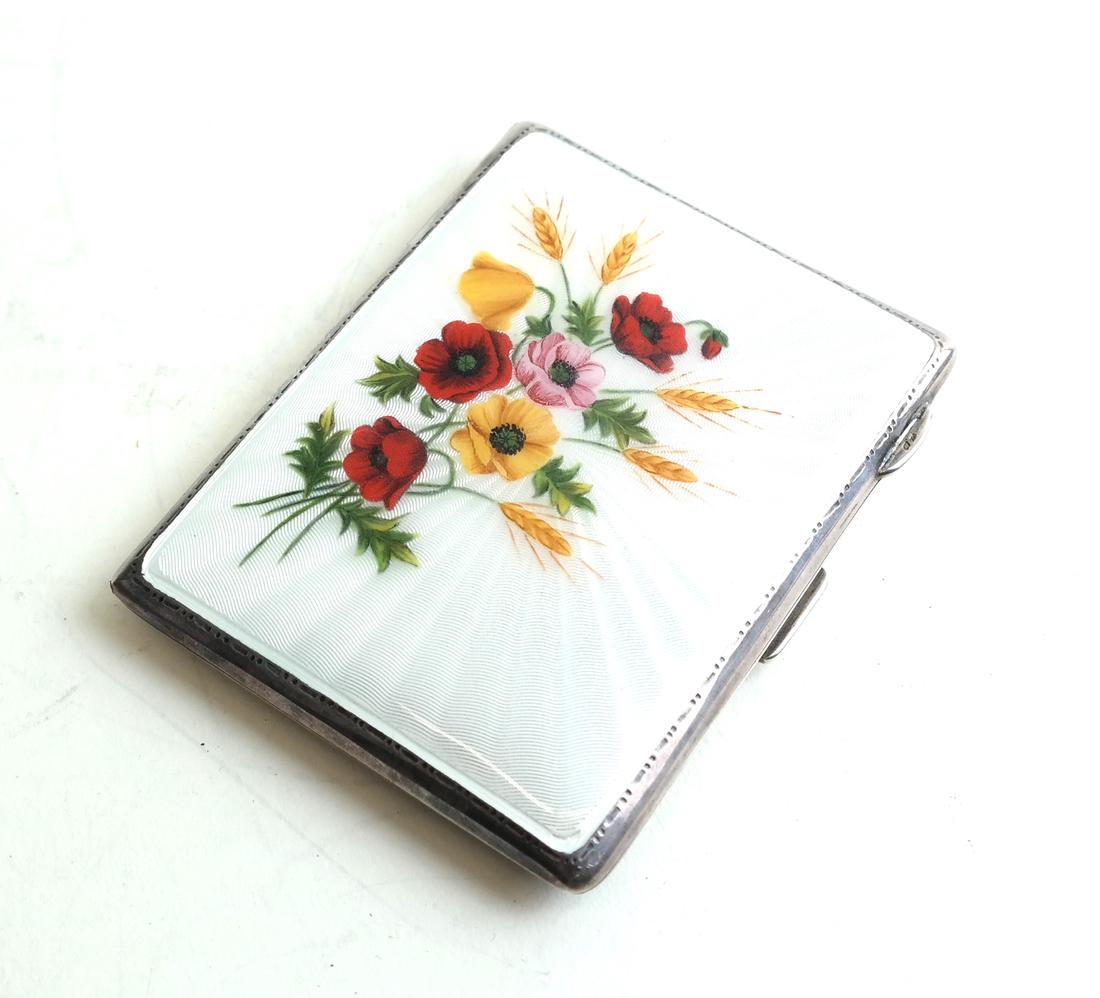 English Silver and Enamel Compact: An english silver and enamel case with an image of floral decoration.