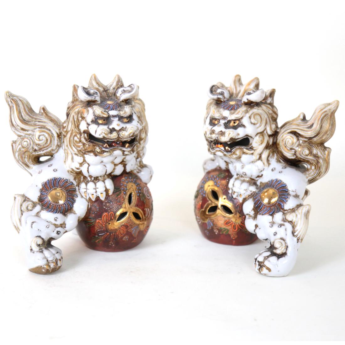 Pair Of Satsuma Foo Dogs: Pair of rearing glazed porcelain foo dogs atop balls. [7 1/4"].