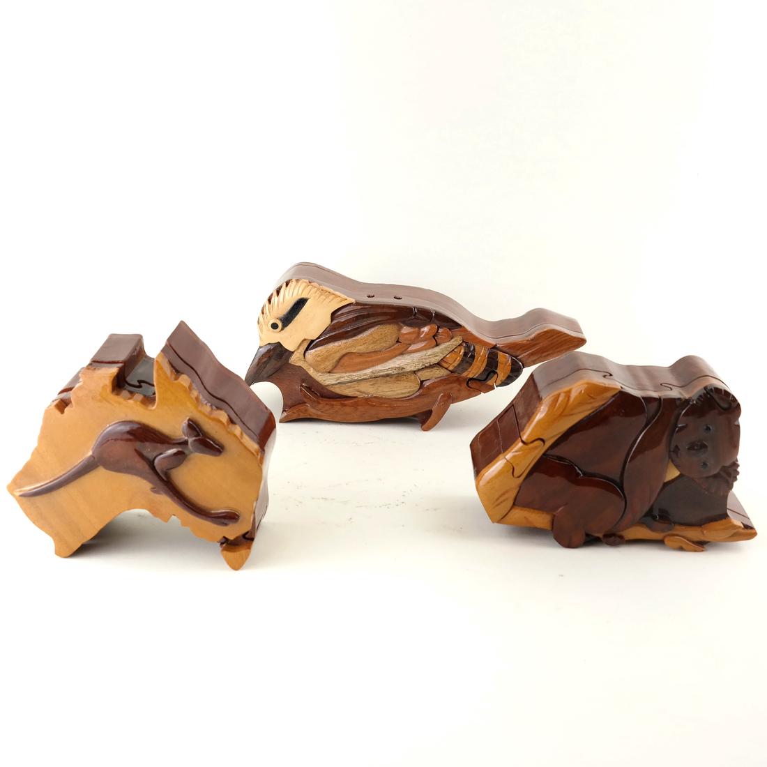Three Puzzle Boxes: One puzzle box in a koala-bear form together a mocking bird-form and kangaroo-form box. [4" H x 6 1/2"-9"].