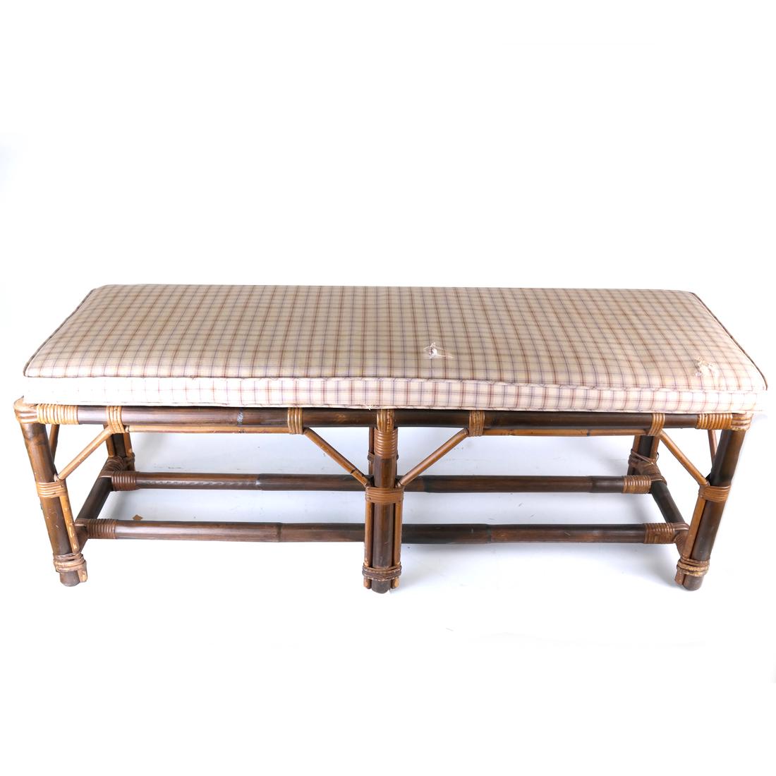 Rattan Bench with Upholstered Seat: Rattan bench with upholstered seat [17 1/2" H x 49" L x 15 1/2" D]. Some light overall wear; few minor tears to upholstery.