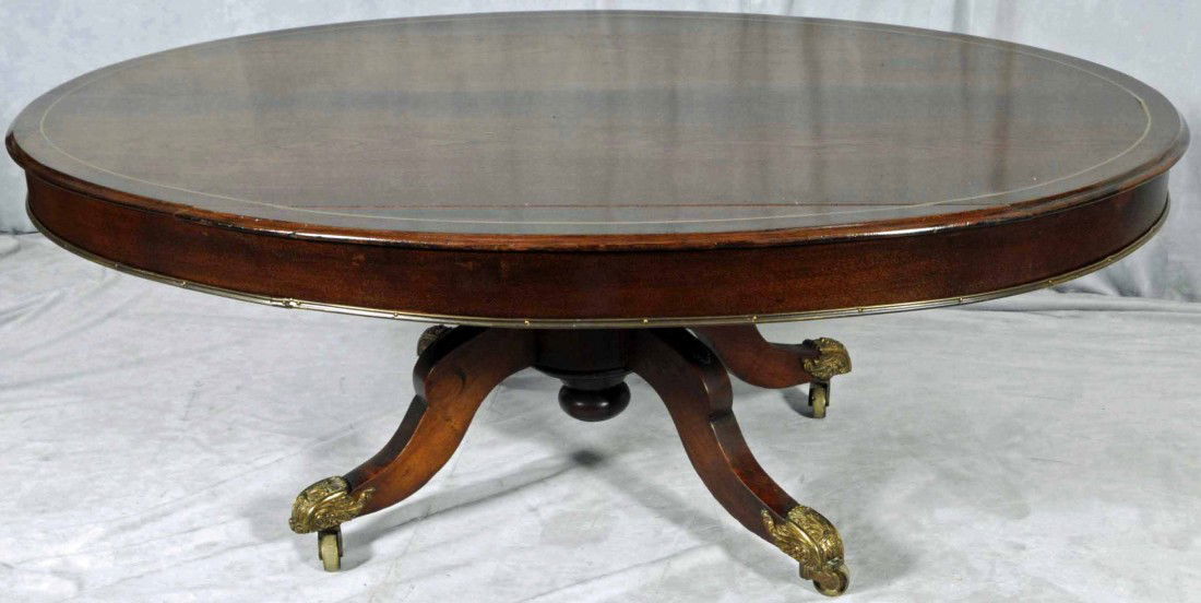 ANTIQUE ENGLISH WALNUT OVAL LOO TABLE. SHAPED TOP: ANTIQUE ENGLISH WALNUT OVAL LOO TABLE. SHAPED TOP WITH BRASS BANDING, RESTING ON FOUR LEGS WITH BRASS PAW & BALL FEET. TABLE HAS BEEN CUT DOWN. SPLIT IN THE TOP. 18" H X 49" W X 31 3/4" D.