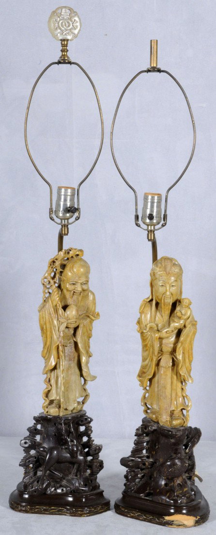 2 CHINESE CARVED SOAPSTONE FIGURES/LAMPS. ONE DEPIC: 2 CHINESE CARVED SOAPSTONE FIGURES/LAMPS. ONE DEPICTS A WISEMAN W/ FRUIT AND THE OTHER IS A WISEMAN HOLDING A CHILD. CARVED SOAPSTONE VASES. WOOD BASES. 17" H.