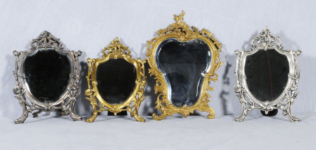 4 METAL OPEN WORKED TABLE MIRRORS. ALL HAVE FLORAL: 4 METAL OPEN WORKED TABLE MIRRORS. ALL HAVE FLORAL DECORATION. 2 ARE GILT METAL & 2 ARE SILVER PLATED. 16" H X 11" W. (TK)