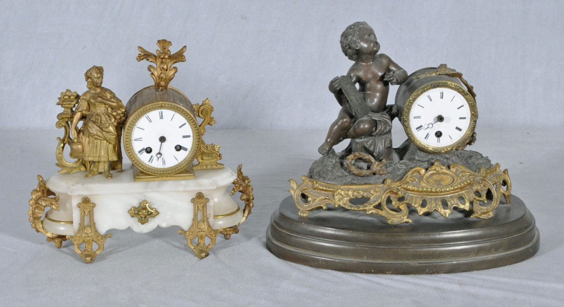 2 ANTIQUE SPELTER MANTEL CLOCKS. ONE HAS A FIGURE: 2 ANTIQUE SPELTER MANTEL CLOCKS. ONE HAS A FIGURE OF A LADY HOLDING FRUIT ON AN ALABASTER BASE, AND THE OTHER HAS A CUPID HOLDING A TABLET. 9" H X 12" W X 5" D. (TK)