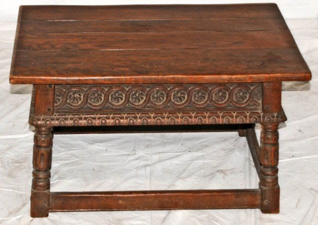 CALIFORNIA CARVED OAK MISSION STYLE COFFEE TABLE. F: CALIFORNIA CARVED OAK MISSION STYLE COFFEE TABLE. FLORAL AND SCROLLED FRIEZE, RESTING ON TURNED LEGS W/ A LOWER STRETCHER. PEG CONSTRUCTION. MAKER: ANGELES FURNITURE CO. GOOD. 17"H X 30" W X 18 3/4" D