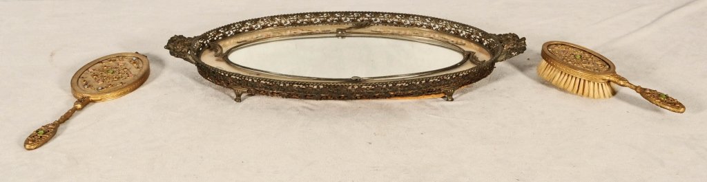 3 PC. BRASS VANITY SET. CONSISTING OF AN OVAL FOOTED : 3 PC. BRASS VANITY SET. CONSISTING OF AN OVAL FOOTED VANITY TRAY, WITH A BEJEWELLED BRUSH & MIRROR. 13" X 4 1/4". GOOD. TRAY 21 1/4" X 11 1/4".
